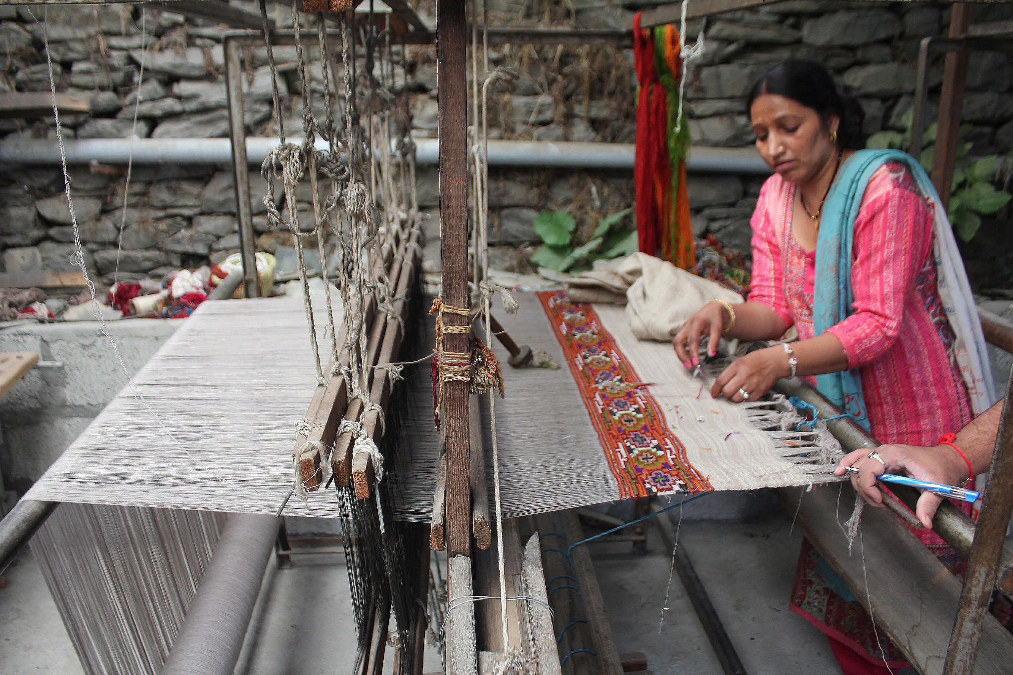 A woman weaving patterned cloth on a traditional handloom, KNT field photograph